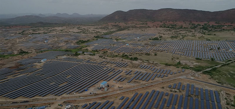 A Big Land With Solar Panels Lying Near Mountains